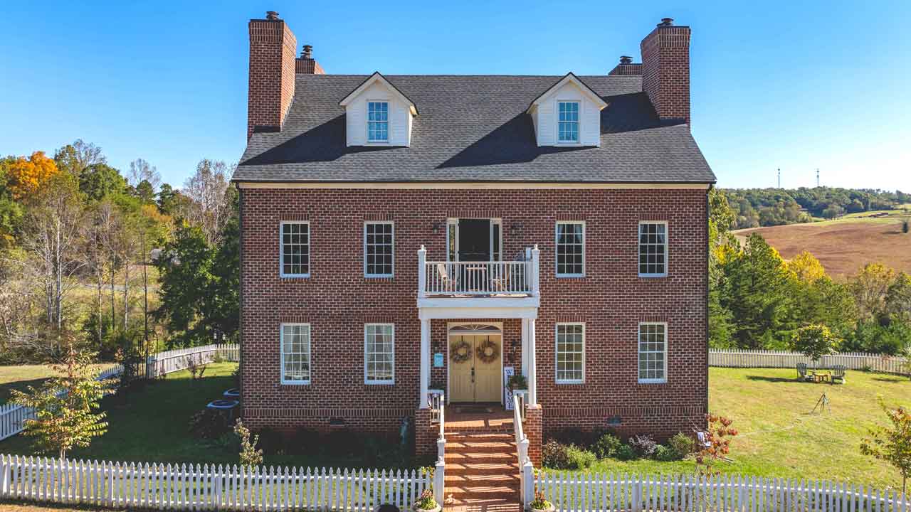 A beautiful and stunning cottage-style home surrounded by lush greenery on 15 acres of land