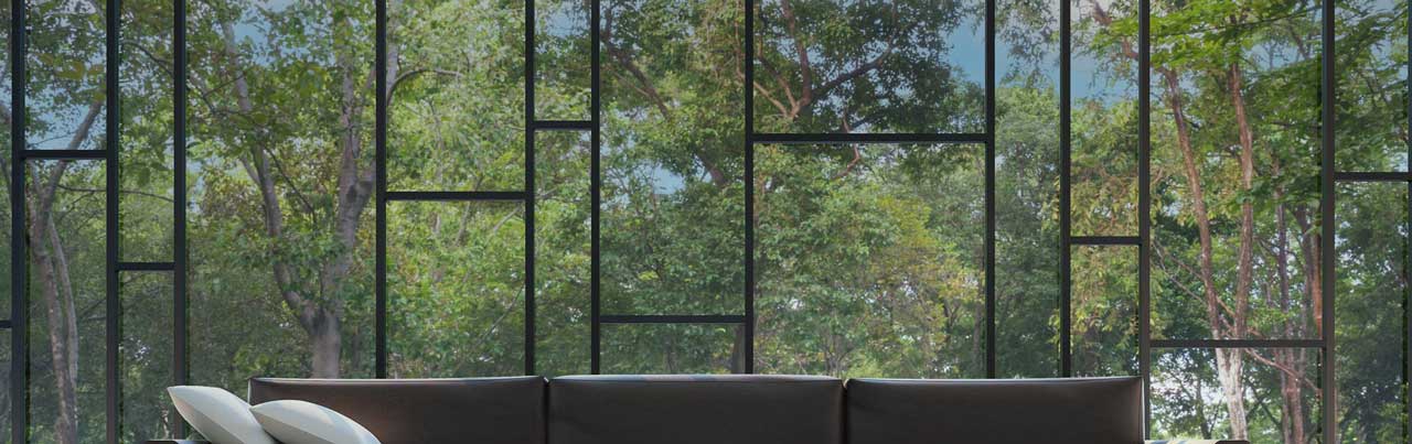 Modern black-framed window with an asymmetrical grid, showcasing lush green trees outside.